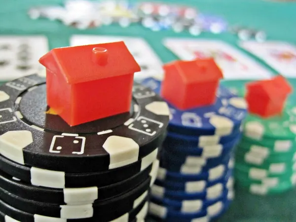 Poker chips and playing cards beside a laptop